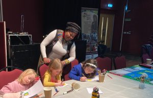 Phati helps children with a crafting session 